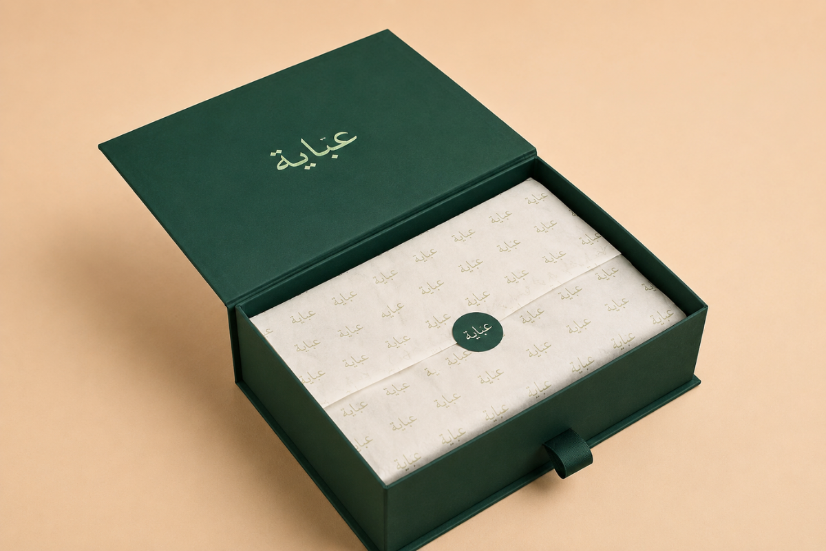 Emerald green abaya box open to reveal cream tissue and wax seal